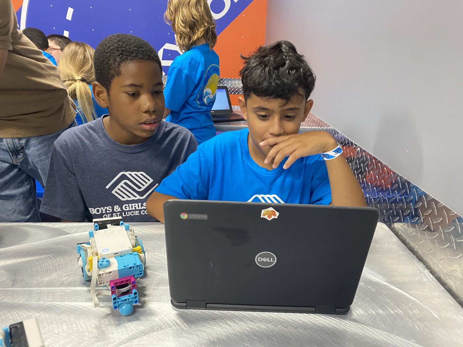 Students showing off their LEGO robotics builds at summer camp